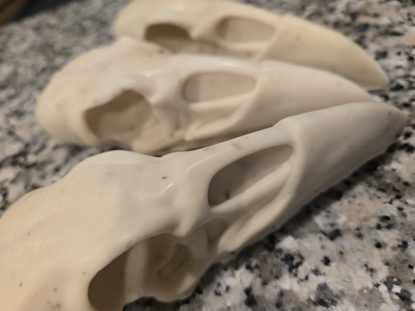Two ceramic duck heads on a speckled countertop