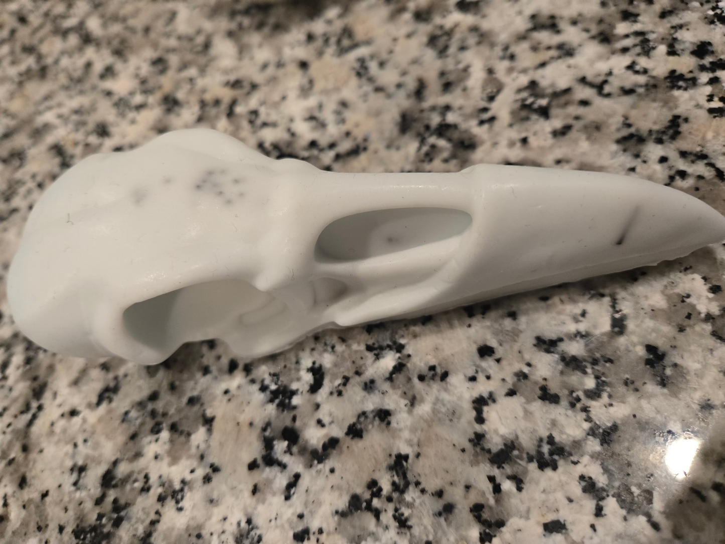 White ceramic object on a speckled granite surface